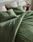 Olive green bedding set on a bed in a bedroom setting