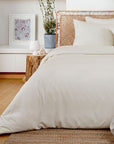 Neatly made bed with ivory bamboo bedding in a bedroom setting.