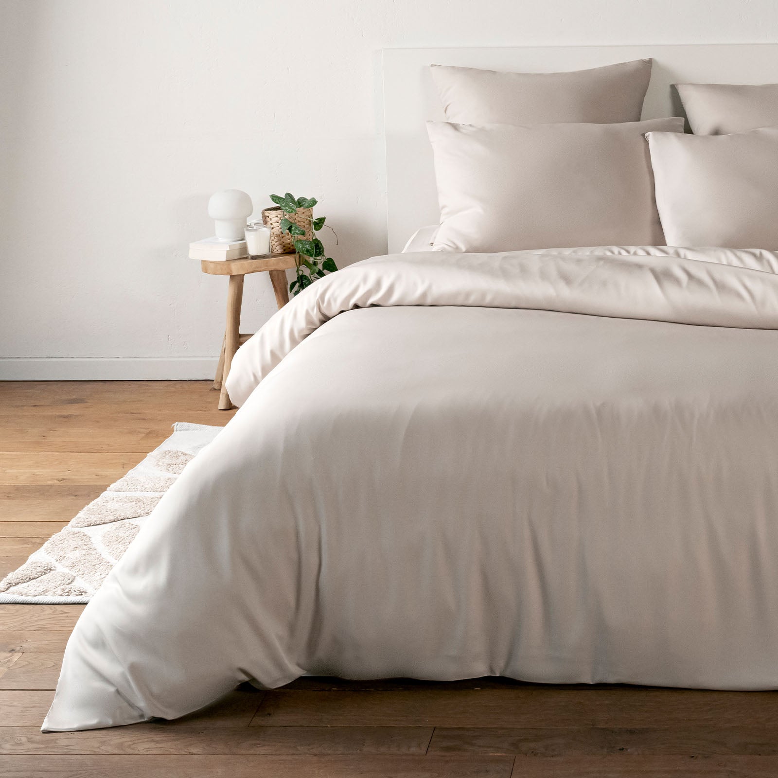 Sand Beige bamboo bedding set on a bed in a bedroom with wooden flooring and a small table