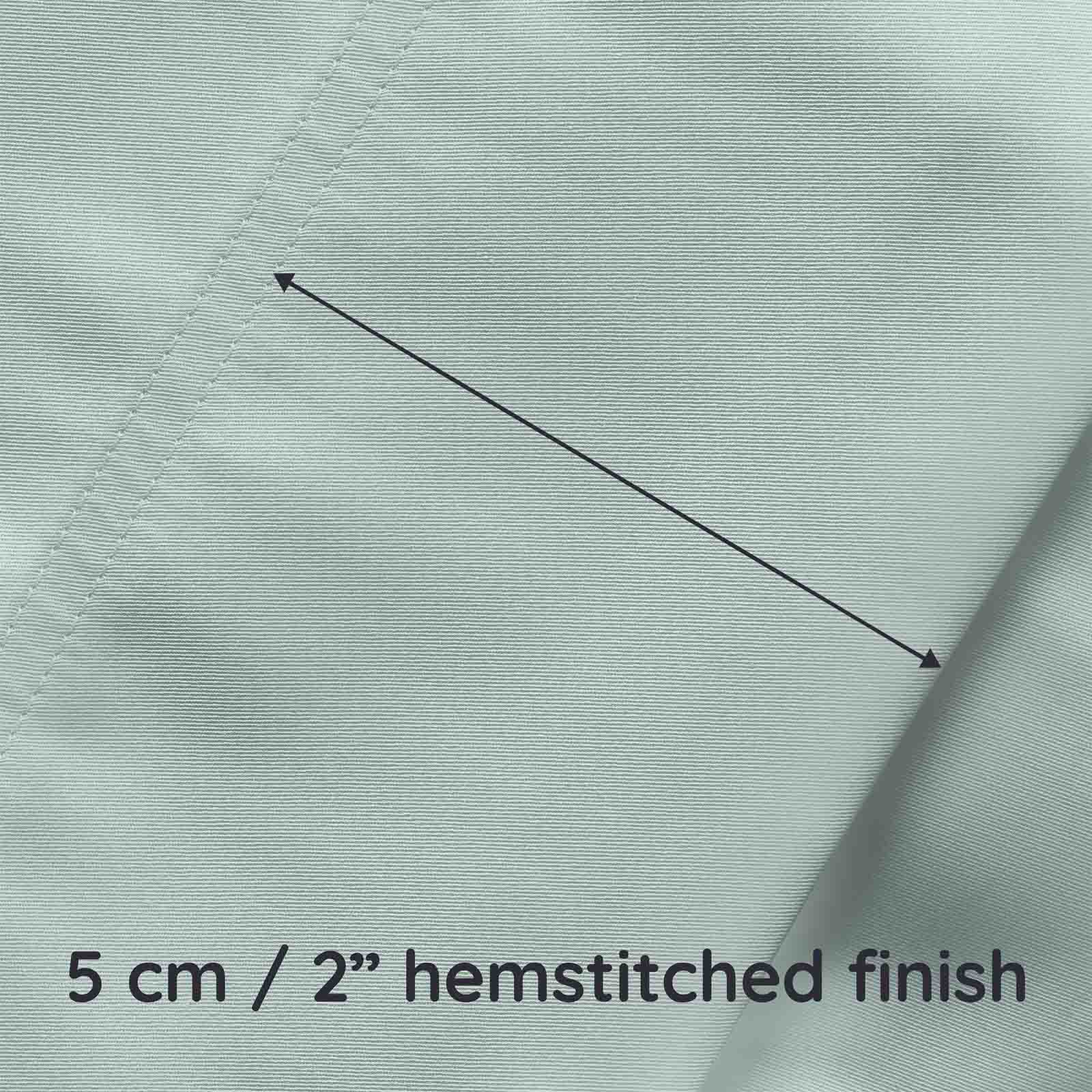 Close-up of light green fabric with a hemstitched finish and measurement text.