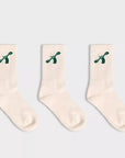 Three pairs of City to Ocean white socks with green designs on a light gray background