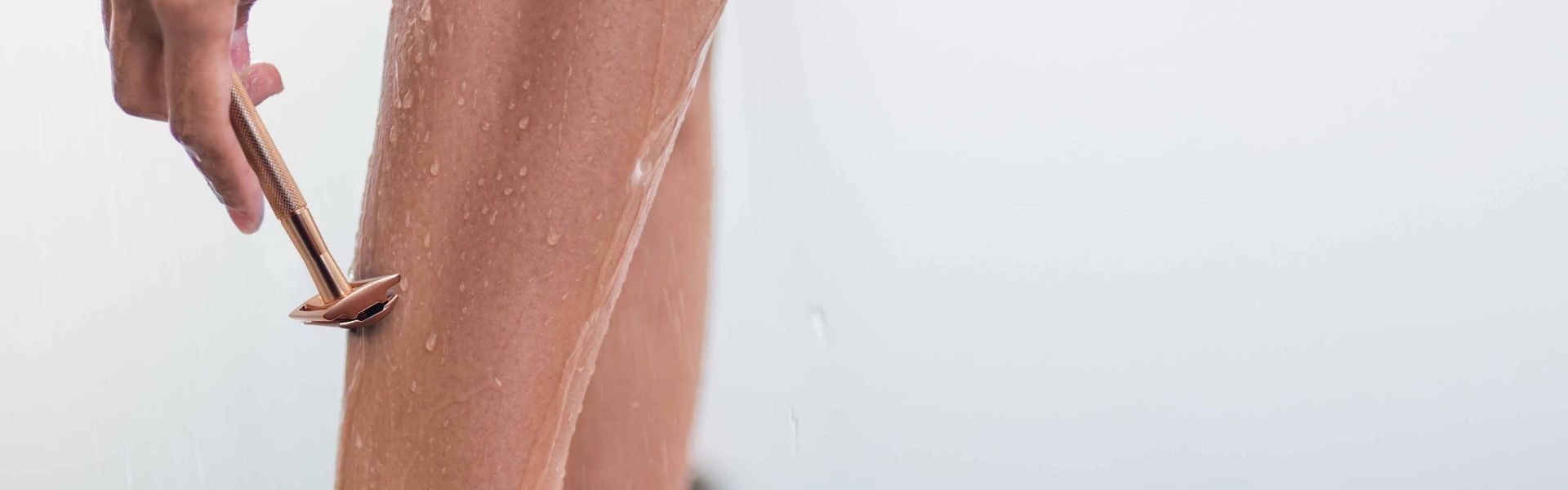 a woman shaving her leg with a bambaw metal safety razor in the shower