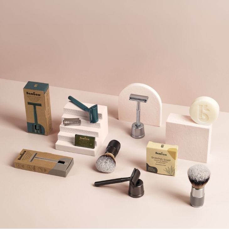 Collection of bambaw shaving tools and accessories on a light pink background