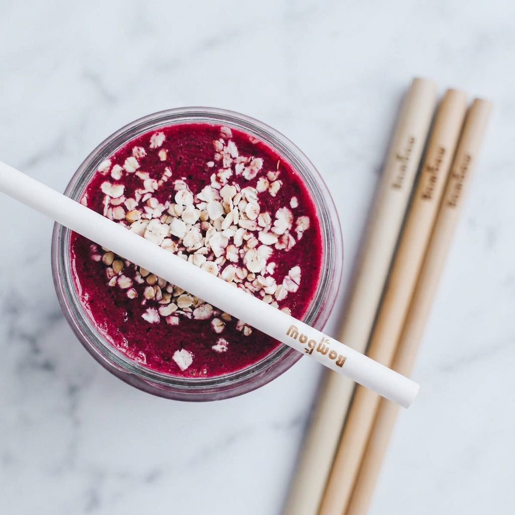 Purple smoothie in a jar with a bamboo straw across the rim
