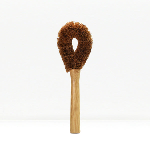 Brown fluffy dish brush with wooden handle on a white background